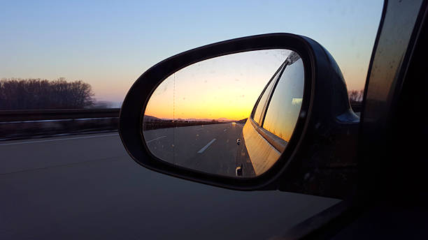 зимний закат боковой вид зеркало автомобиля на шоссе - side view mirror стоковые фото и изображения