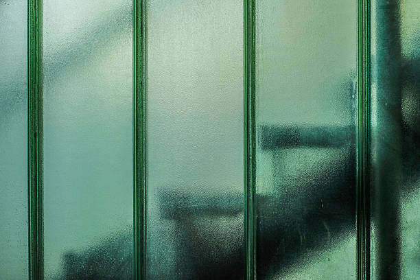 istock Old backlit concrete stairs behind thick glass wall 639220586