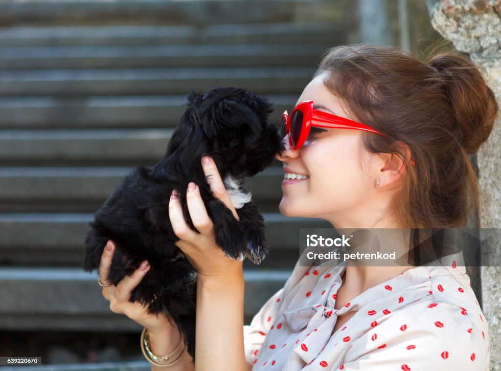 Young brunette woman hugging her lap dog puppy Young brunette woman hugging her lap dog puppy. Retro style Black Color Stock Photo