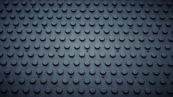 A top view on a PVC dark industrial floor with raised circular studs. The image has an 16:9 aspect ratio.