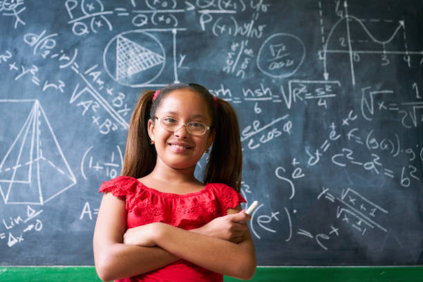 Portrait Happy Girl Resolving Complex Math Problem On Blackboard stock photo