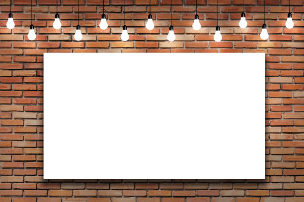 Blank white frame on brick wall with bulb lights lamp. stock photo