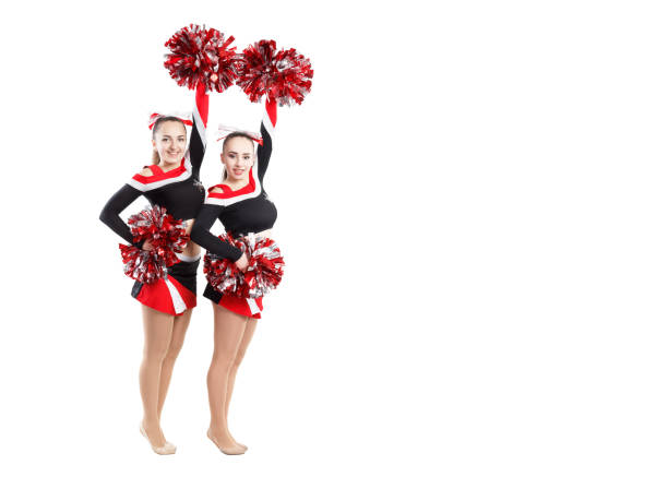 istock Two professional cheerleaders posing at studio. Hands raised up. 639236842