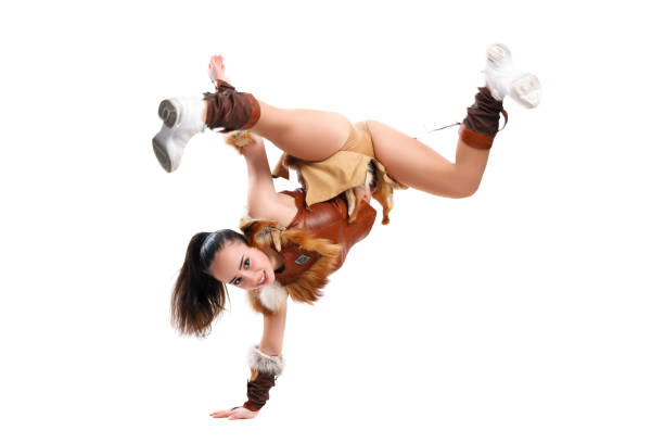 Young professional cheerleader dressed in a warrior costume standing on one hand. Horizontal splits