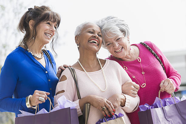 tre donne anziane multietniche fuori a fare shopping - bag senior adult outdoors friendship foto e immagini stock