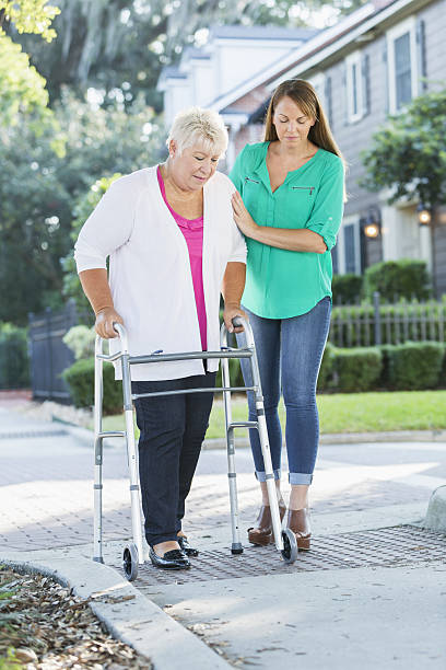istock Women helping her aging mother use walker 639243222