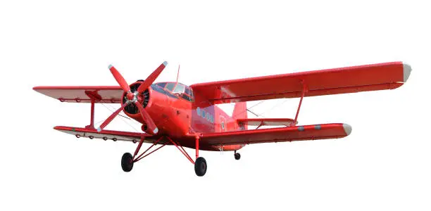 Front side view of red airplane biplane with piston engine and propeller. Isolated on white background