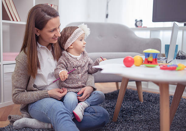 istock Young mother with her baby working or studying on laptop 639245062