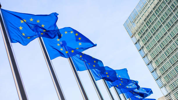 флаги европейского союза перед зданием берлеймонта - eurozone debt crisis стоковые фото и изображения