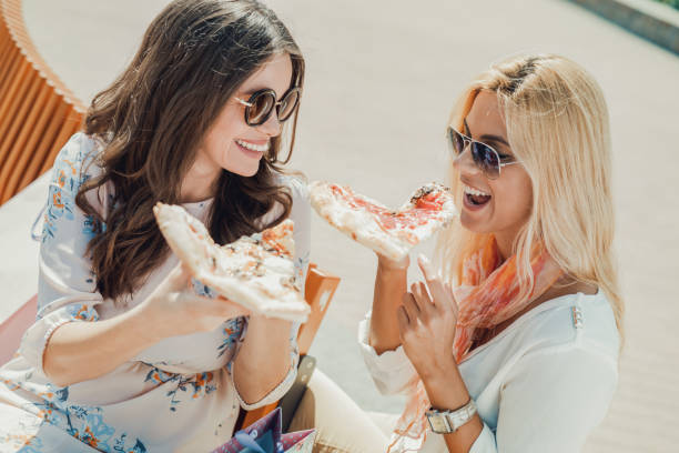 istock Two young women eating pizza 639253584
