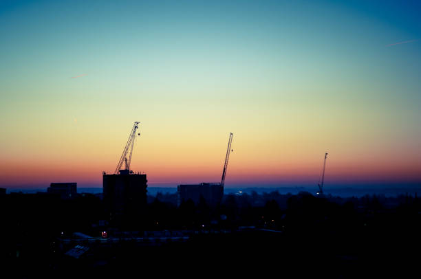 istock Cityscape sunrise with three construction work cranes silhouette 639257030
