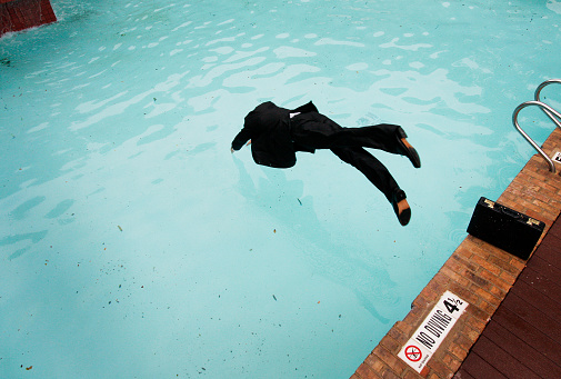 Businessman diving into a shallow pool 