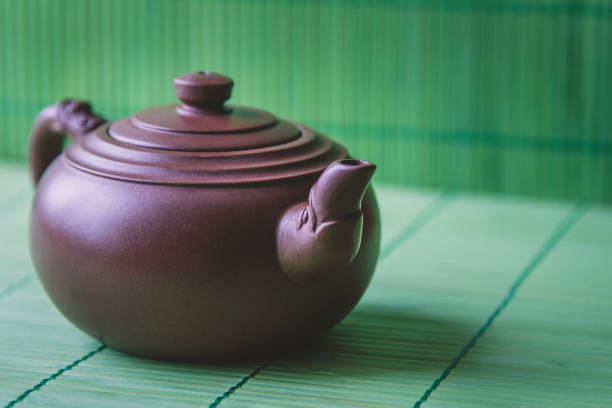 istock Close-up ceramic teapot on green bamboo wooden background. 639259062