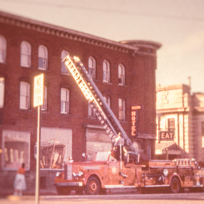 A fire truck raising its ladder at a hotel.