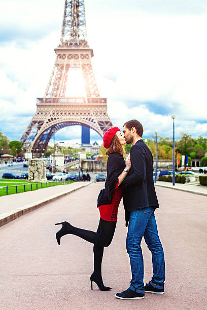 romântico jovem casal a beijar perto da torre eiffel em paris - paris france eiffel tower love kissing imagens e fotografias de stock