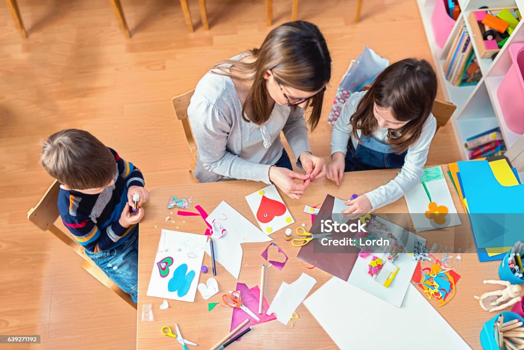 Insegnante prescolare con bambini che hanno attività creative - Foto stock royalty-free di Bambino