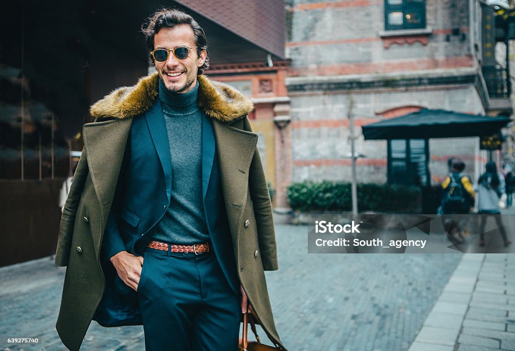 Elegant gentleman Handsome desirable gentleman in suit, out in the city. He is walking and carying a bag. Men Stock Photo