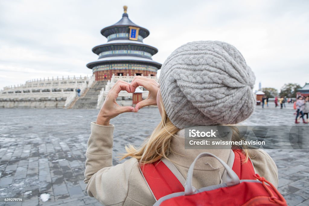 Woman making heart shape finger frame, Temple of Heaven-Beijing Young woman traveling makes a heart shape finger frame on the hall of prayer for good harvest of Temple of Heaven,Beijing. Love people travel concept. Adult Stock Photo