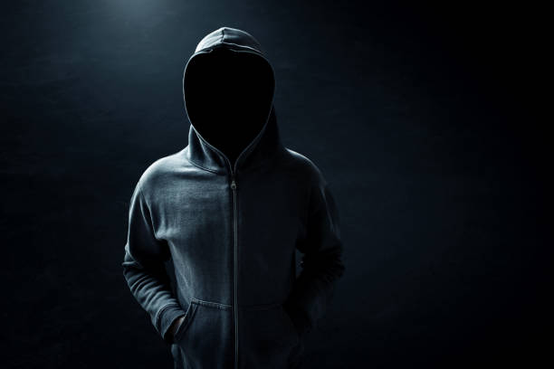 Hacker standing alone in dark room stock photo