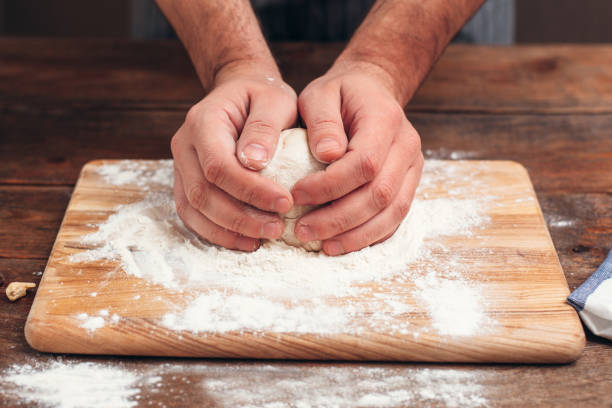 istock Baker holding raw dough in hands close-up 639294356