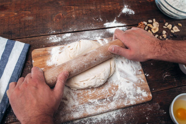 istock Man rolling dough on cutting board, cook pov 639294386