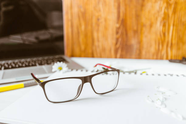 istock table with laptop glasses pen  flowers 639300236