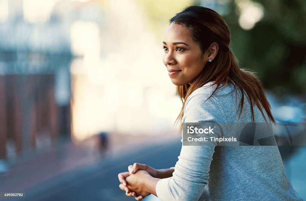 Doing some thinking on the balcony Shot of an attractive young businesswoman standing on her office balcony Women Stock Photo