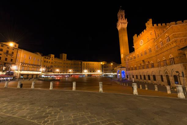 Piazza del Campo (Campo square) by night with the tower del Mangia (Tower of Mangia) and the Town Hall in the downtown of Siena, Toscana (Tuscany), Italy