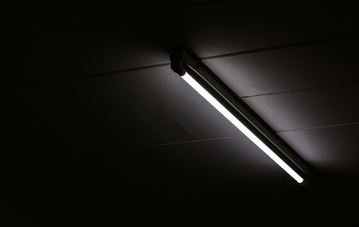 Detail of a fluorescent light tube mounted on a wall with copy space for any design