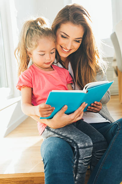 istock Mother and daughter reading a book 639313324