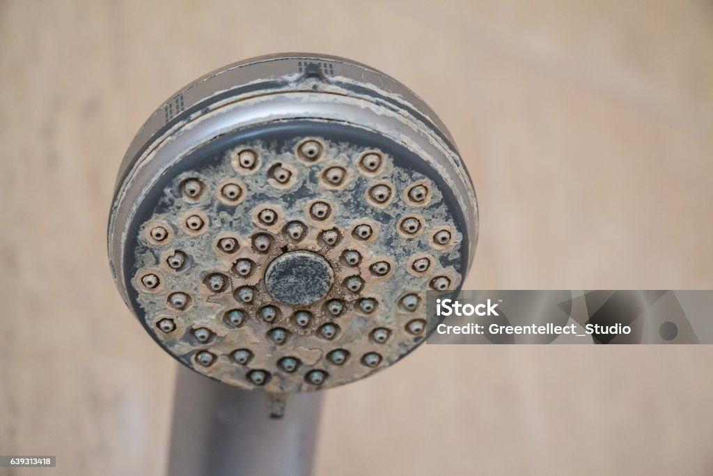 Hard water deposit and rust on shower tap Hard water calcium deposit and corrosion on chrome shower tap Water Stock Photo
