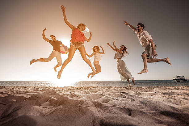 istock Below view of happy people jumping on the beach. 639315364