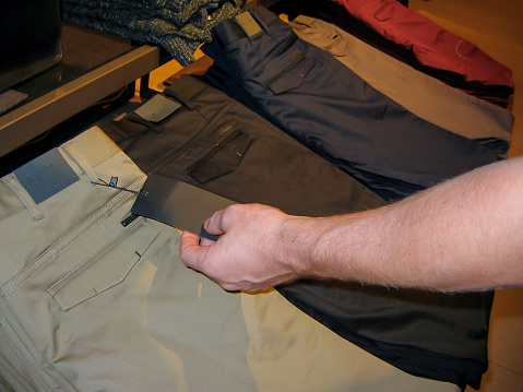 Young man checking label price trouser