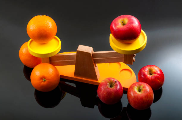 comparación del concepto de manzanas con naranjas - weight scale apple comparison balance fotografías e imágenes de stock