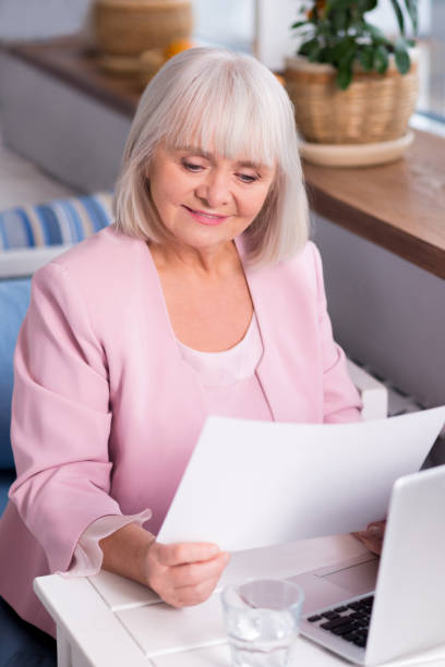 istock Enthusiastic senior lady studying the report 639326810
