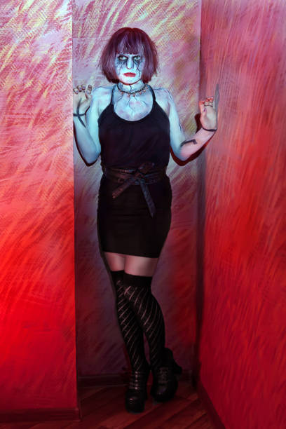 istock girl with makeup zombies standing in red wall 639330648