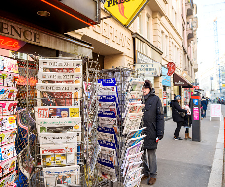 Paris, France - January 21, 2017: Man purchases International newspapers from a kiosk newsstand featuring headlines with Donald Trump inauguration as the 45th President of the United States in Washington, D.C