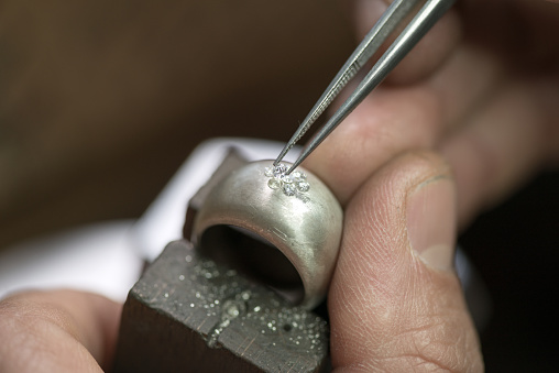Professional gemstone settings jewellery craft laboratory: Placing diamond on ring