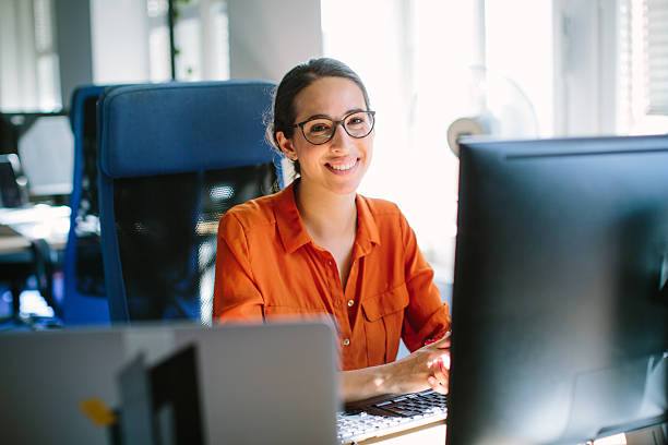 sorrindo confiante para a câmera - pc desktop pc women desk - fotografias e filmes do acervo