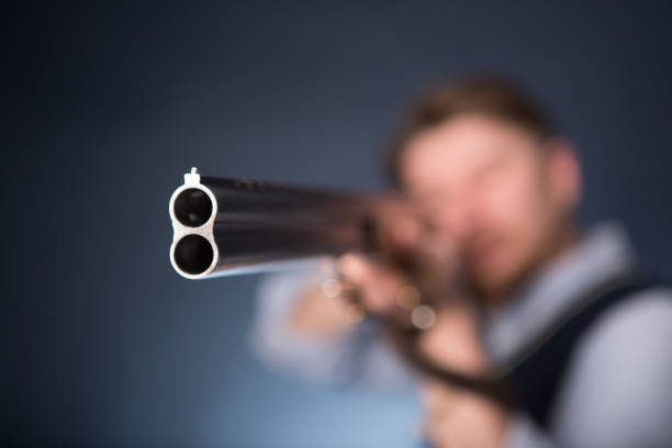 Front view of police officer (20s) aiming a gun.  Focus on gun.
