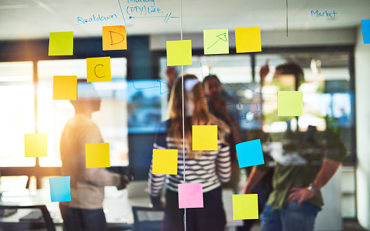 Shot of colleagues having a brainstorming session with sticky notes at work