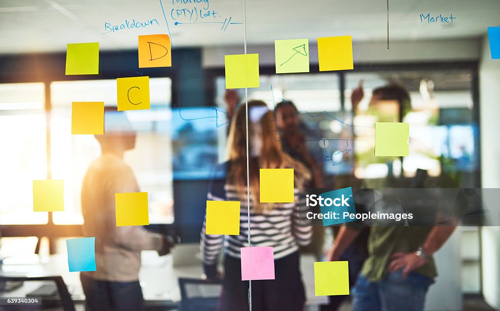 Creative thinkers in their natural habitat Shot of colleagues having a brainstorming session with sticky notes at work Adhesive Note Stock Photo