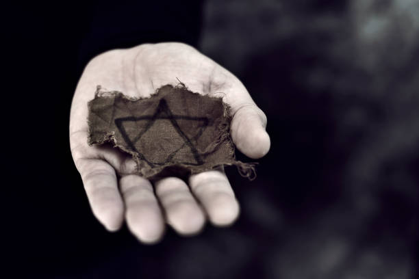 closeup of a ragged Jewish badge in the palm of a young man