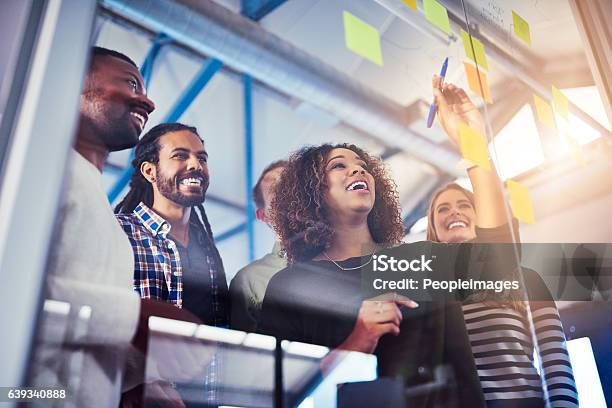 Working Their Way Through Different Solutions Stock Photo - Download Image Now - Teamwork, Office, Marketing