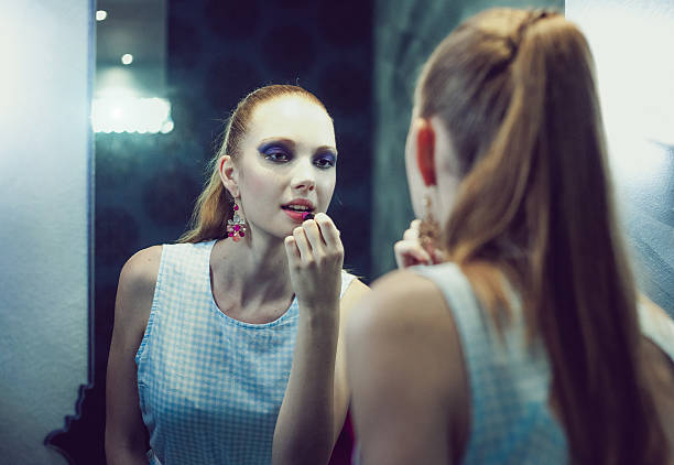 adolescente regardant miroir application maquillage - femme fatale one person make up cool photos et images de collection