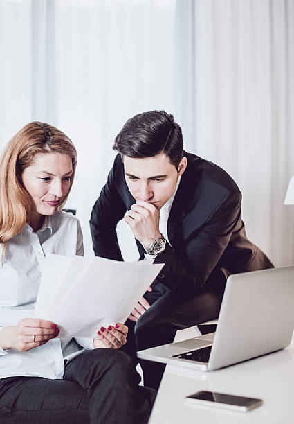 istock Two Business People Discussing in a Hotel Room, Using Laptop 639342122