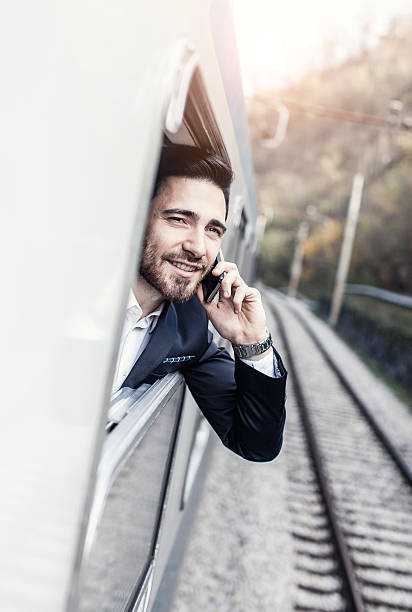 istock Businessman Talking on The Phone Looking Through Train Window 639344228