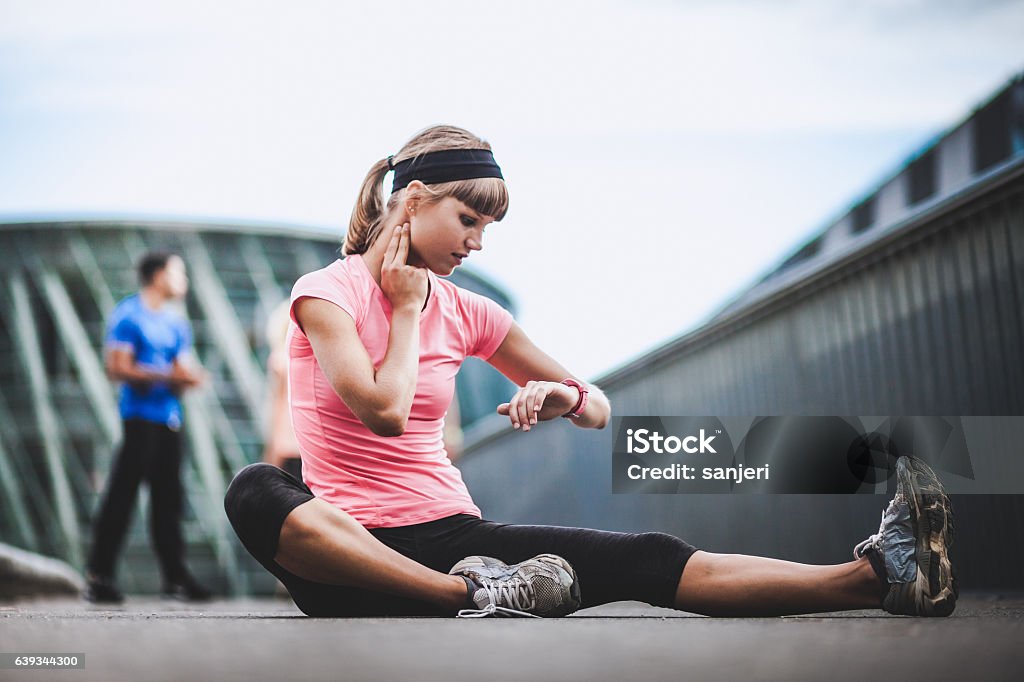 Athlete Checking Out Her Heart Rate Group of Young Athletes Warming up Outdoors Activity Stock Photo