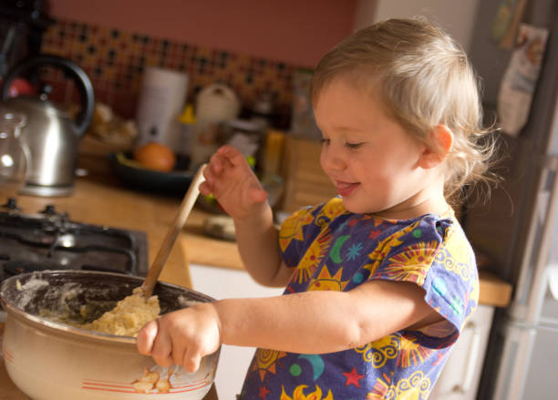 istock Cute toddler baking and eats away a dough 639345320