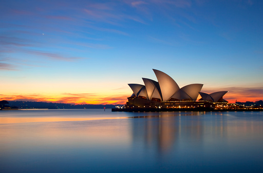 Sydney Australia - May 21, 2011: Pre-dawn sunlight lights up the sky over Sydney, Australia. The iconic shape of the Opera House stands out against the lightening sky.